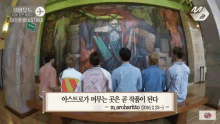 a group of people are standing in front of a large painting with a sign that says astro