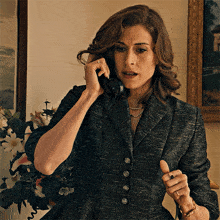 a woman in a suit is talking on the phone