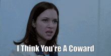 a woman says " i think you 're a coward " in front of a door