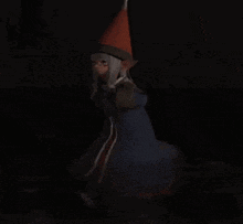 a woman in a witch costume is standing in the dark .