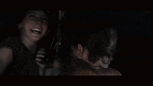three girls are standing next to each other in a dark room .