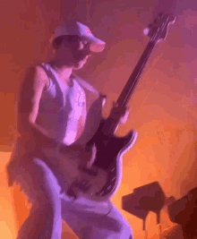 a man is playing a guitar with a red bull hat on