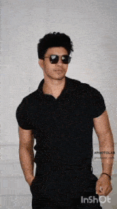a man wearing sunglasses and a black polo shirt