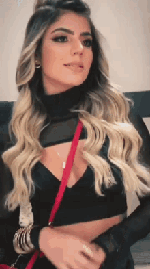a woman wearing a black top and a red purse