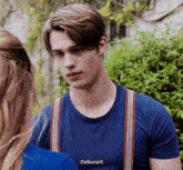 a young man wearing suspenders and a blue shirt with the word daikunart on the front