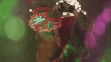 a man in a mask is walking on a stage with fireworks behind him .