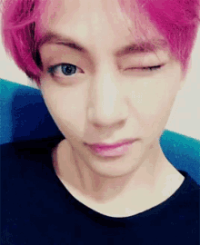 a close up of a person with pink hair making a wink