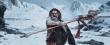 a man with a beard is holding a trident in the snow .