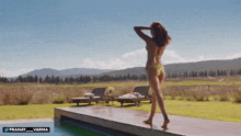 a woman in a bikini is standing next to a swimming pool with the hashtag pranay_varma