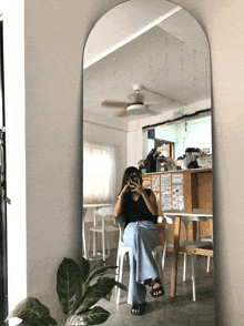 a woman is taking a picture of herself in a large mirror