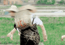 a blurry picture of a person in overalls and a hat