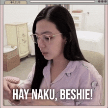 a woman wearing glasses says hay naku beshie while looking at her phone
