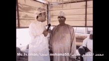a man talking into a microphone with the words mc.tv.oman/mohama50 on the bottom of the screen
