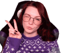 a woman wearing glasses and a purple sweater is giving the peace sign