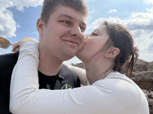 a woman kisses a man on the cheek while wearing a black shirt with a green arrow on it