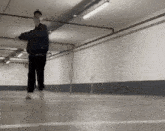 a person is walking in a parking garage with a skateboard .