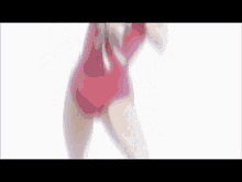 a woman in a pink swimsuit is standing in front of a white background and covering her face with her hands .