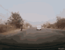 a car is driving down a road with a person riding a motorcycle .