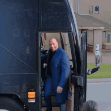 a man in a suit is getting out of a bus