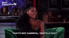 a woman sitting on a green couch with the words that 's not harmful that 's a fact