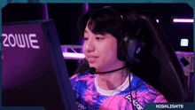 a man wearing headphones is sitting in front of a computer screen with the word zowie on it