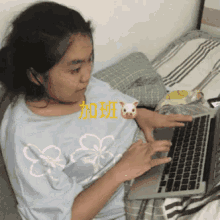 a girl is typing on a laptop with chinese writing on the top
