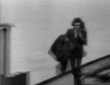 a man in a suit and tie is walking down a set of stairs