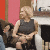 a woman is sitting on a couch and smiling