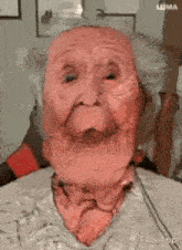 a close up of an elderly woman 's face with a red mask on it .
