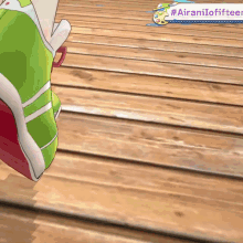 a green shoe is standing on a wooden floor with a purple banner that says #airanilofifteen