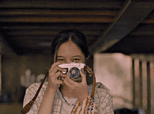 a woman is taking a picture with a camera that says olympus on it
