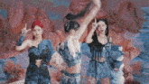 a group of three women are dancing in front of a rocky landscape ..
