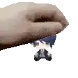 a hand is holding a small figurine of a boy in a suit .