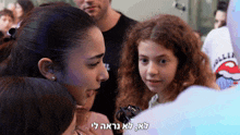 a girl in a rolling stones shirt is talking to a woman