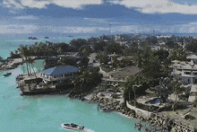an aerial view of a tropical island with a boat in the foreground