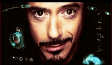 a close up of a man 's face with a screen behind him