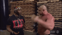 a man wearing a black shirt that says aew is talking to another man