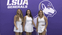 three women stand in front of a lsua generals sign
