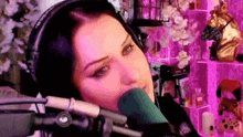 a woman wearing headphones and a microphone is sitting in front of a microphone .