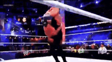 two men are wrestling in a wrestling ring with a crowd watching