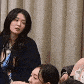 a woman in a blue sweater is sitting next to a man in a chair .