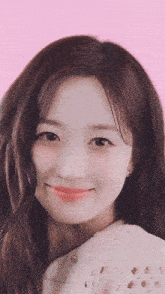a close up of a woman 's face with pink background