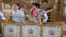 a group of people are standing around a couch in a room
