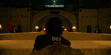 a person with the number 067 on their back sits at a table