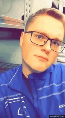 a man wearing glasses and a blue jacket with the word oma on it