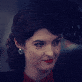 a woman wearing red lipstick and a black jacket