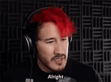 a man with red hair is wearing headphones and talking .
