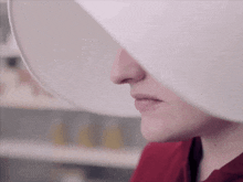 a close up of a woman 's face with a white hat on her head