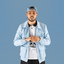 a man wearing a light blue jacket and a hat with the word aldi on it