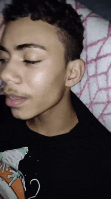 a close up of a young man 's face with his eyes closed and his mouth open .